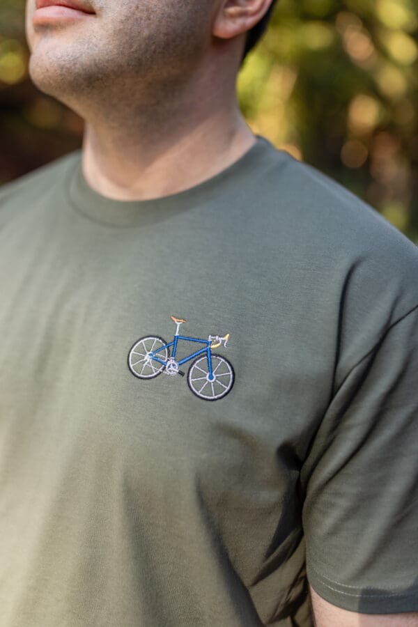 A man wearing a green shirt with a blue bike on it.