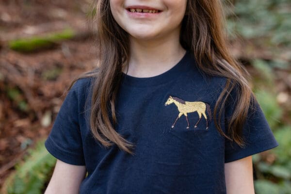 A girl wearing a black shirt with a horse on it.